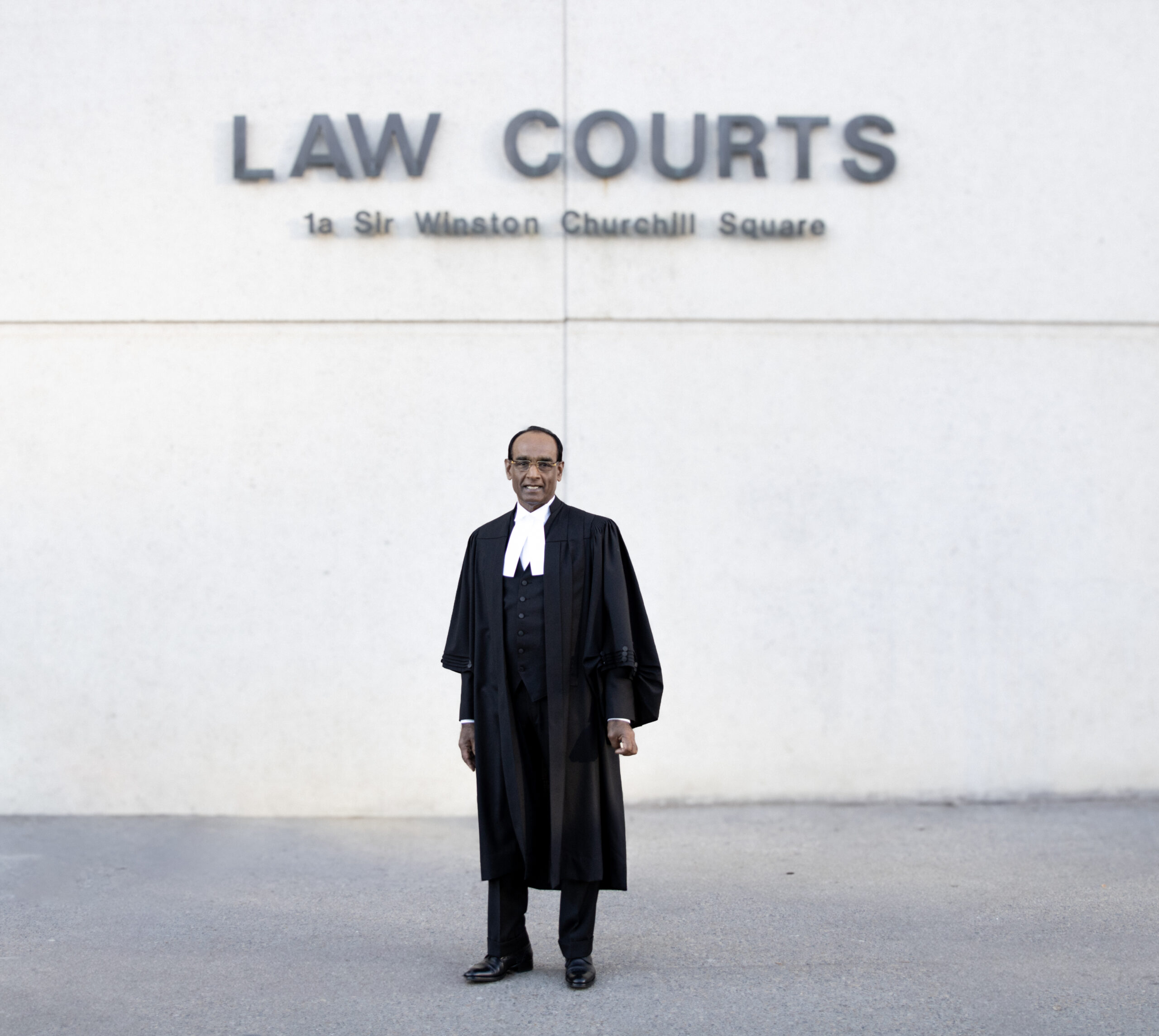 A lawyer in formal attire stands in front of the Law Courts, showcasing professionalism and the legal environment.